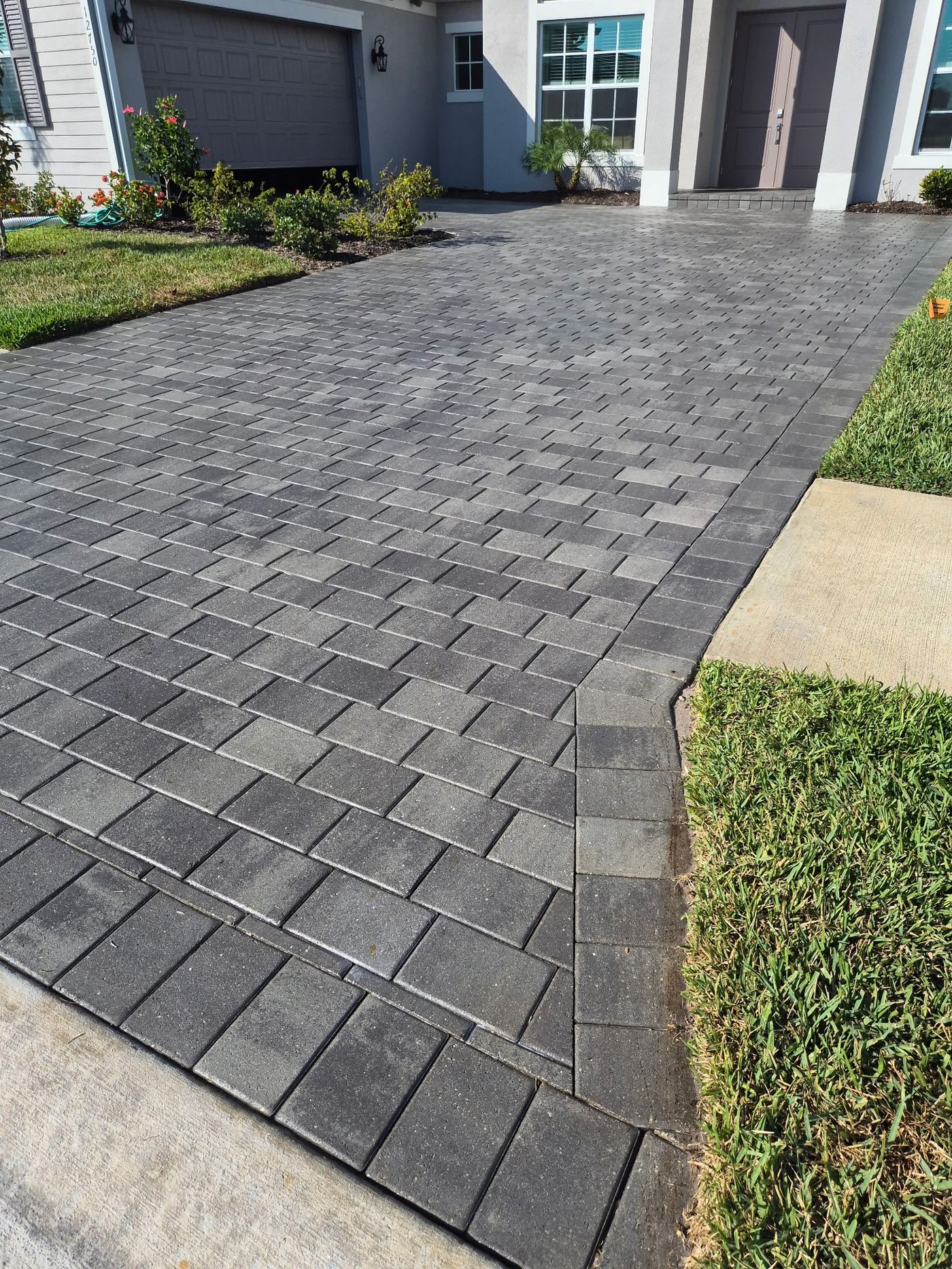 Color-enhanced sealed pavers leading to front door in Sarasota FL